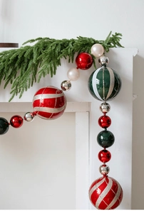 Macro detail of 15cm painted Christmas ball ornaments hanging on a festive mantle
