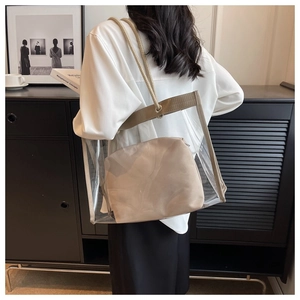 Detail of transparent PVC tote bag featuring a beige fabric inner pouch and rope handles