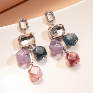 Vue détaillée des boucles d'oreilles géométriques en argent avec cristaux et perles marbrées