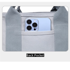 Detail of the back pocket on the grey canvas tote bag showing storage for a smartphone
