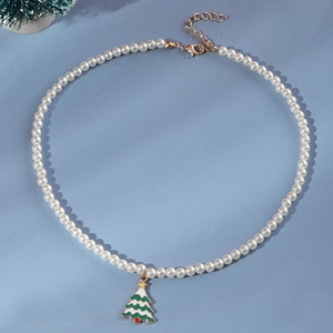 Detail view of pearl Christmas necklace featuring a green tree pendant and golden lobster clasp