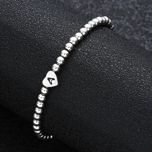Silver bead heart bracelet with letter A pendant on a black professional background