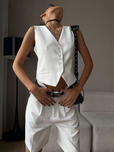 Detail view of white V-neck vest and straight trousers set with high-quality suit fabric
