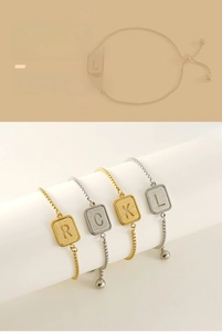 Macro shot of adjustable gold and silver letter bracelets with frosted square pendants