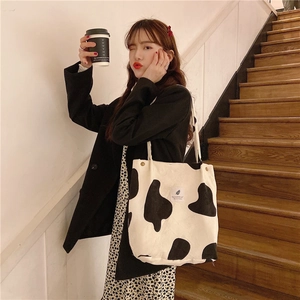 Detail view of large capacity corduroy shoulder bag with black and white cow print