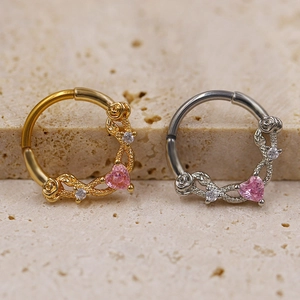 Gold and silver nose rings with pink heart gems and floral vine details on stone