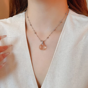 Detail view of a clear spherical crystal pendant on a silver beaded chain for women