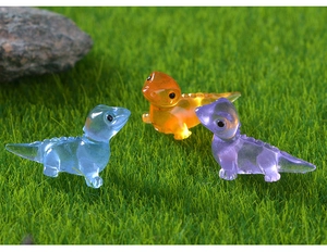 Close-up of three colorful glow-in-the-dark resin lizards on a green artificial lawn