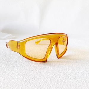 Detailed view of orange oversized shield sunglasses with a transparent gradient finish