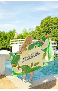 Detail of beach towel with tropical leaf pattern and Happy Summer text in sunny pool setting