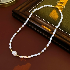 Macro view of gold-plated beaded flower pearl necklace with baroque pearl pendant