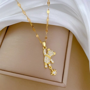 Detail of gold titanium bear necklace with sparkling white zircons and a small star charm