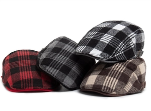 Detail view of four assorted plaid newsboy caps in red, grey, white and brown wool blend