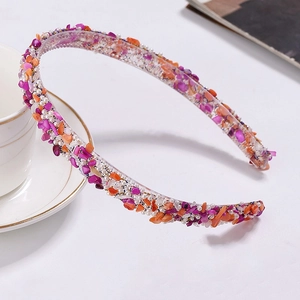 Detail of purple and orange beaded headband with irregular gems and faux pearls