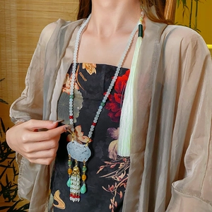 Detailed close-up of a vintage Chinese style necklace with jade lock pendant and tassels