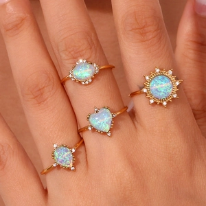 Macro shot of 18K gold plated opal rings in oval, sun, heart and drop shapes with diamonds