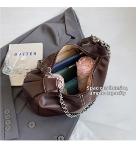 Deep brown tote bag showing large interior space with silver chain and white stitching