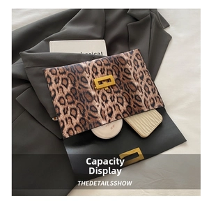 Detail of leopard print clutch capacity showing books and cosmetics inside the envelope bag