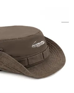 Détail de la broderie Outdoors sur un chapeau de soleil marron à larges bords