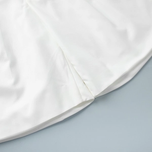 Macro shot of white vest set fabric showing premium stitching and smooth texture