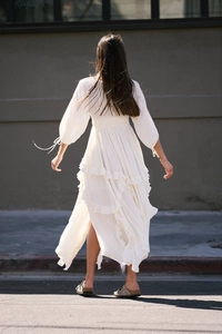 Rear view of white bohemian long dress featuring tiered ruffles and lantern sleeves