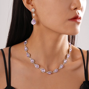 Detail showing elegant pear-shaped purple crystal necklace and matching earrings set