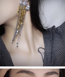 Close-up of elegant long tassel earrings with fireworks wheat design on model