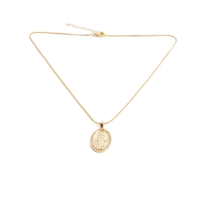 Macro detail of a gold religious oval pendant with embossed virgin mary on white background
