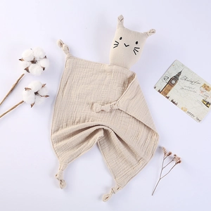 Detail of baby muslin comforter with embroidered cat head and soft knotted corners