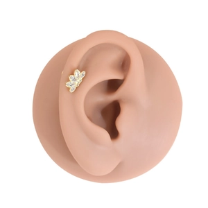 Detail showing gold G23 titanium ear stud with five-petal marquise zircon on ear model