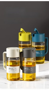 Detail view of 550ml glass oil dispensers with automatic lids in four modern colors