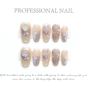 Detailed close-up of handmade press-on nails with 3D roses, pearls and glitter gradients