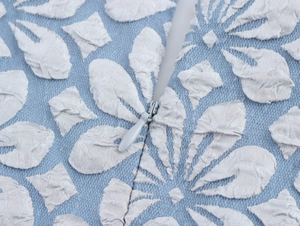 Nahaufnahme der hellblauen Jacquard-Stoffstruktur und des unsichtbaren Reißverschlusses