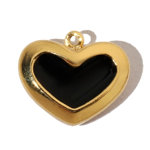 Close-up of a heart pendant featuring black enamel center with a gold-tone metal frame