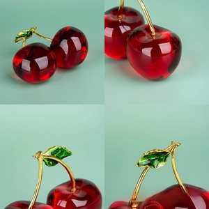 Macro detail of red crystal cherries with gold stems and green enamel leaf decor