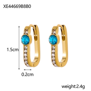 Detailed side view of 1.5cm gold U-shaped earrings with blue crystal and white diamonds
