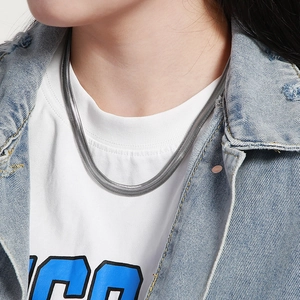 Close-up of a silver flat snake bone chain necklace worn on a person for a trendy look