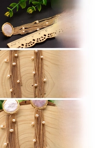 Detailed view of long tassel earrings with natural pearls and 18K gold plating