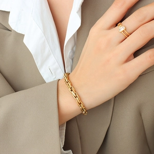 Chunky 18k gold plated chain bracelet and gemstone ring worn with a blazer