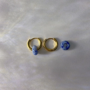 Detail of 18k gold plated hoop earrings with detachable blue stone texture pendants