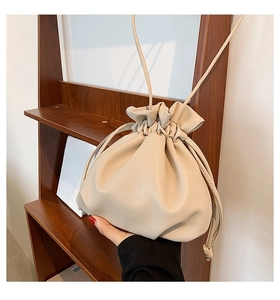 Detail einer beigen Handtasche in Wolkenform aus weichem Kunstleder zum Ziehen
