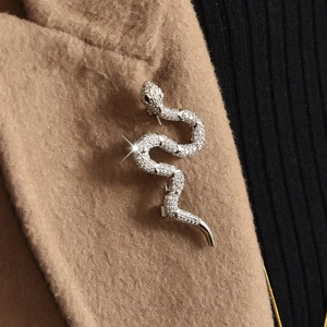 Silver snake brooch with zircons pinned on a camel wool coat collar for a luxury look