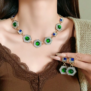 Macro detail of vintage necklace and earrings with green emerald gems and crystals
