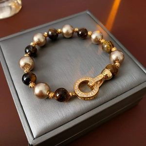 Detail of vintage gold plated bracelet with tiger eye stones and champagne pearls
