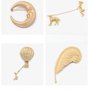 Detailed views of vintage baroque gold brooches featuring moon face and artistic figures