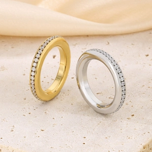 Macro detail of gold and silver full diamond stainless steel rings on rock surface