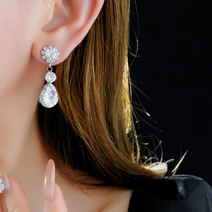 Macro shot of silver crystal flower earrings with sparkling teardrop rhinestones