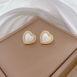 Close-up of heart stud earrings featuring white mother of pearl and zircon stones
