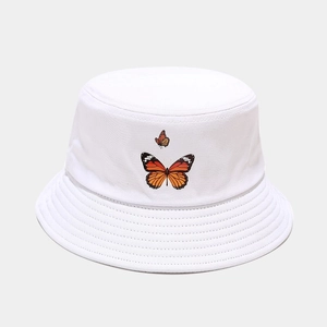 Détail du chapeau bob blanc en toile avec motifs papillons orange et coutures renforcées
