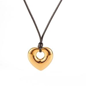 Golden hollow heart pendant necklace with black wax rope cord on white background